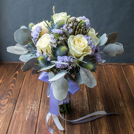 white rose (9 pcs.), eryngium, violet statice, brunia, eucalyptus, packaging, ribbon